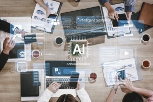Overhead view of a team working at a table with laptops and documents, overlaid with artificial intelligence icons representing AI tools, data analysis, and digital marketing.